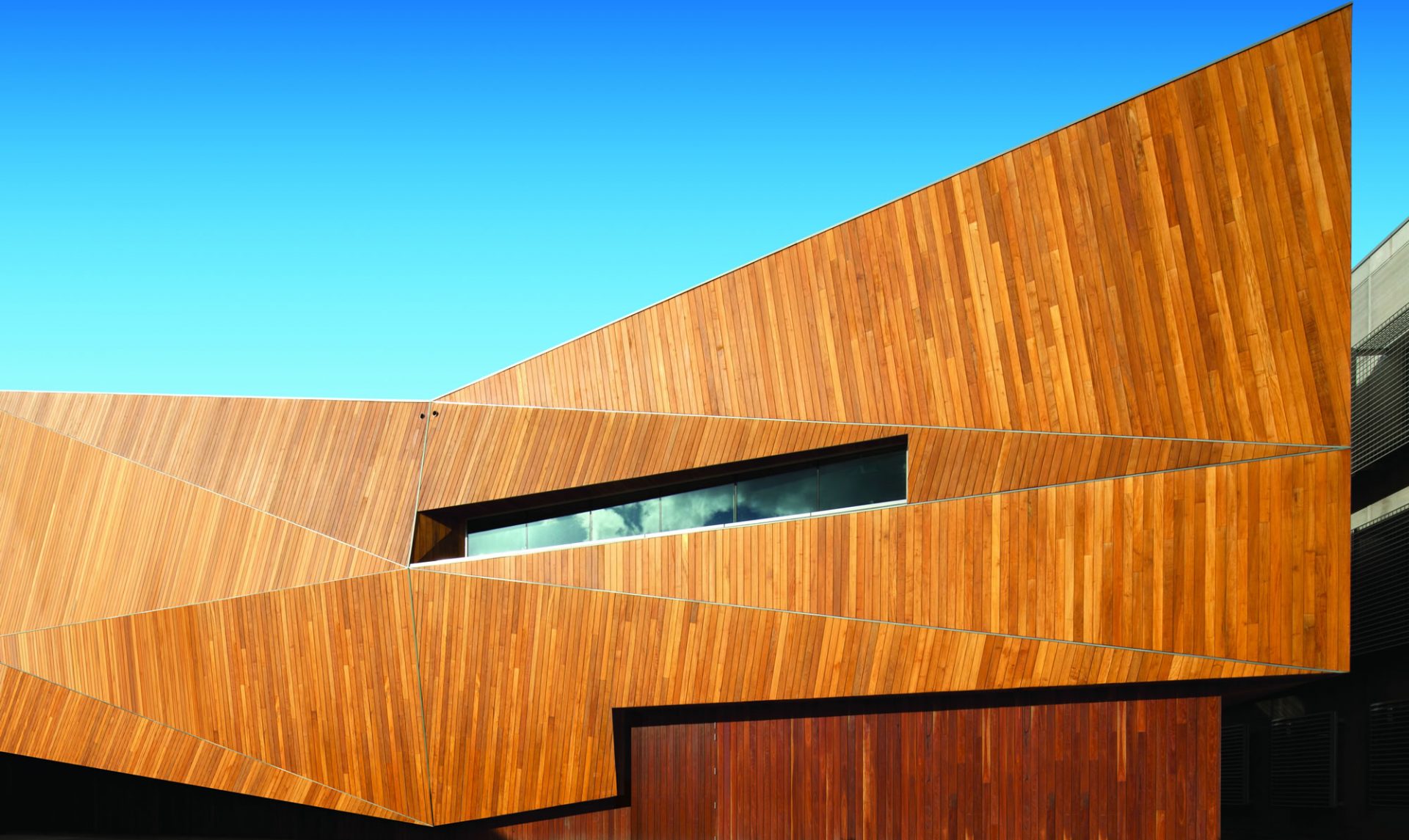 Exterior of architecturally designed house with a slanted dark timber roof