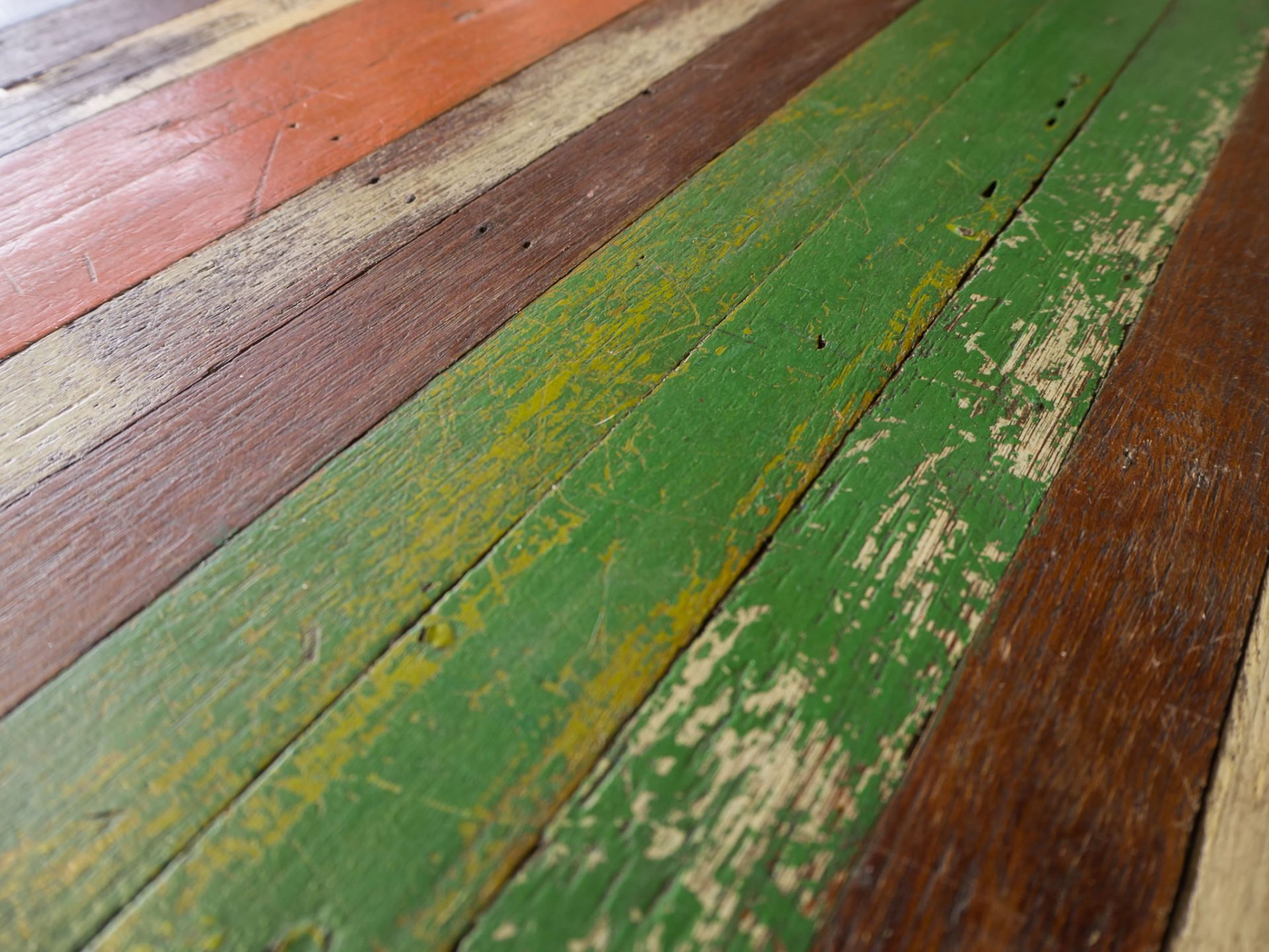Stained timber deck with weathered dark green damage