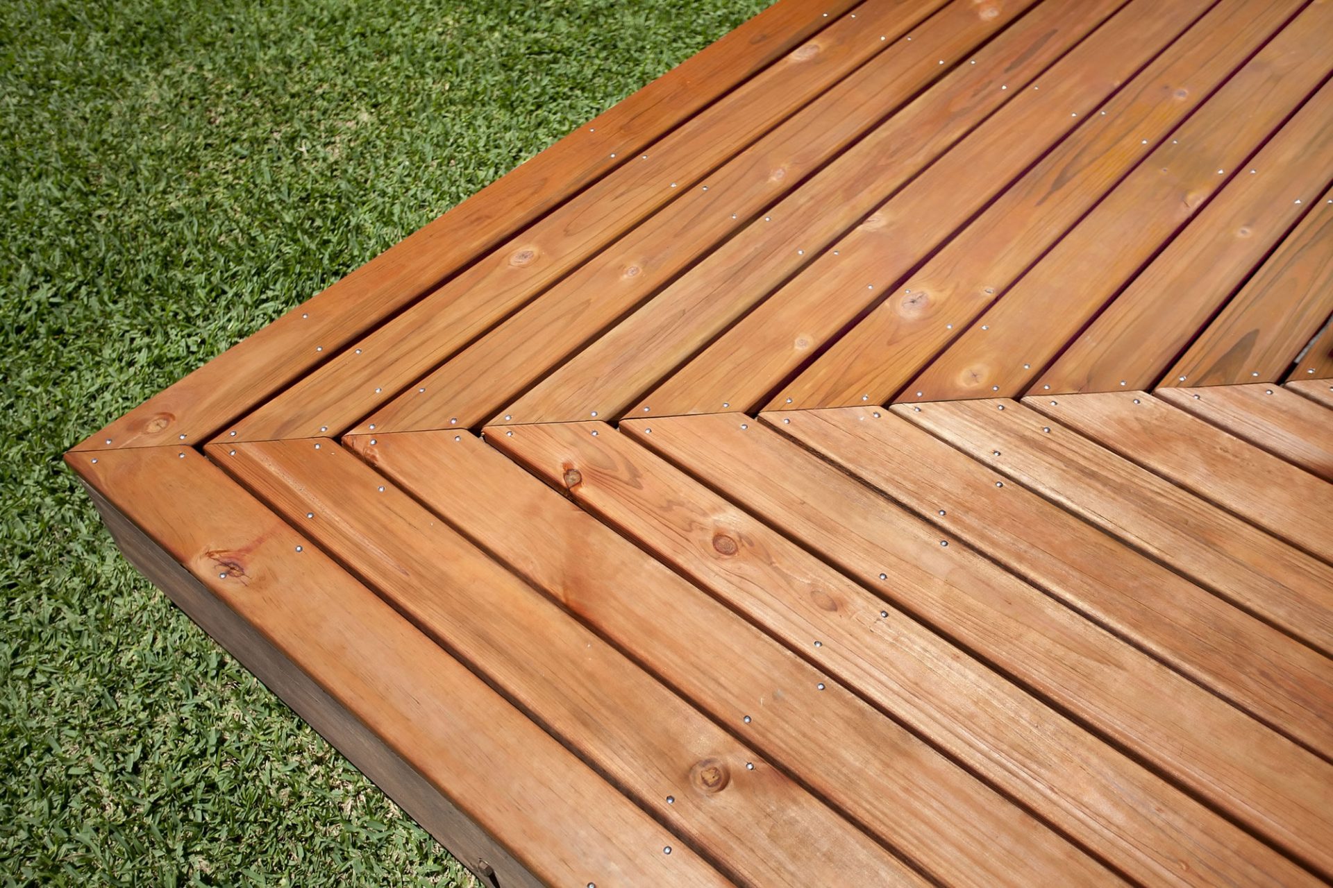 Dark timber deck in on lawn of backyard