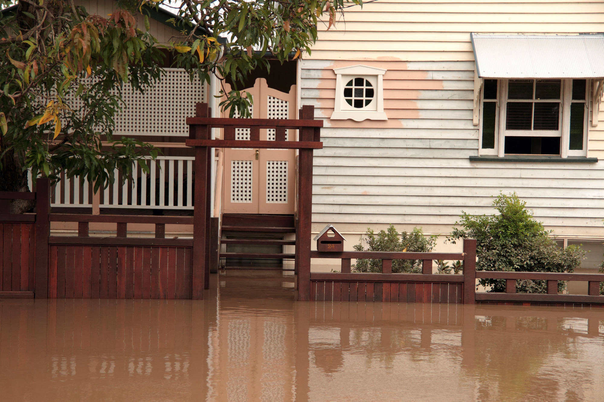House surrounded by flood water up to the front deck